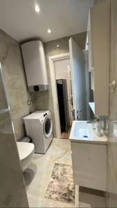 a bathroom with a toilet and a washing machine at Studio City Center in Tirana