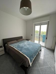 ein Schlafzimmer mit einem Bett und einem großen Fenster in der Unterkunft A casa di Milly in Triggiano