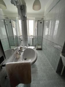 ein weißes Badezimmer mit einem Waschbecken und einem Spiegel in der Unterkunft A casa di Milly in Triggiano