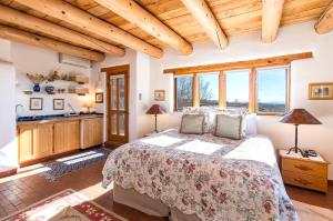 um quarto com uma cama grande num quarto com tectos em madeira em City Views at Alma Compound, 2 Bedrooms, Sleeps 4, Walk to Plaza, Fireplace em Santa Fé