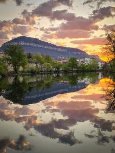 a reflection of a mountain in the water at sunset at Le Raffiné in Millau