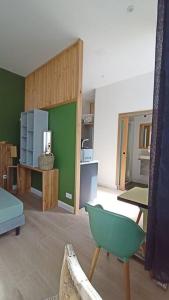a living room with a green wall and a chair at Le Raffiné in Millau