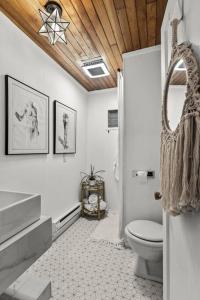 uma casa de banho com um WC branco e um tecto de madeira em Cedar and Sage em Tacoma