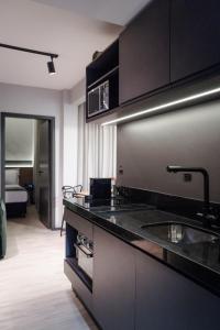 a kitchen with black cabinets and a sink at Cidade das Bicicletas in Joinville