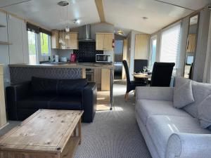 a living room with a couch and a table at Marsh Farm Holiday Park in Great Yarmouth