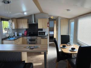 a kitchen with a table and a dining room at Marsh Farm Holiday Park in Great Yarmouth