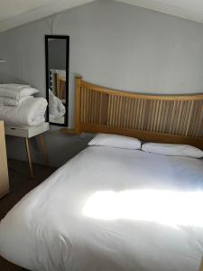 1 dormitorio con 1 cama blanca grande y espejo en Marsh Farm Holiday Park en Great Yarmouth