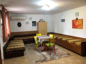 een kamer met bedden en een tafel en stoelen bij Къща за гости Апартамент за гости РАЙ с Арбанаси до гр Велико Търново in Arbanasi