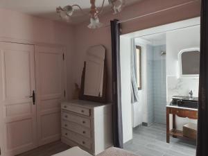 a bathroom with a sink and a dresser with a mirror at Les Violettes in Mons