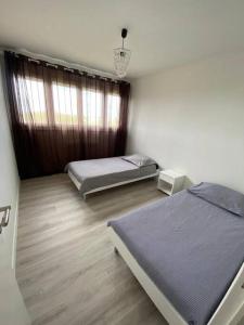 sypialnia z 2 łóżkami i oknem w obiekcie Appartement Gien w mieście Gien