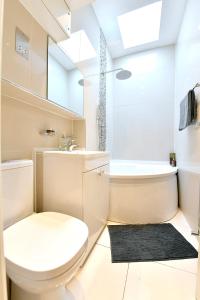 a white bathroom with a toilet and a sink at Hendon Escape Luxury Apartment with En-suite Bath in Hendon