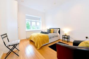 1 dormitorio con 1 cama con manta amarilla y ventana en Hendon Escape Luxury Apartment with En-suite Bath, en Hendon