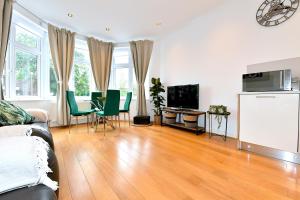 a living room with a couch and a table with chairs at Hendon Escape Luxury Apartment with En-suite Bath in Hendon