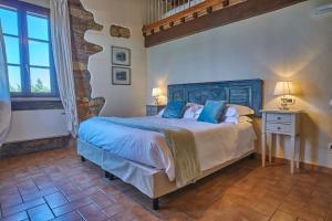 a bedroom with a large bed with blue pillows at Podere Gli Olmi in Cecina