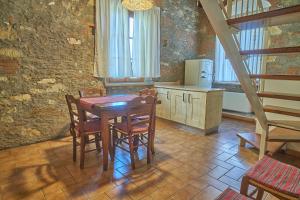 Podere Gli Olmi في تشيزينا: مطبخ مع طاولة وكراسي في غرفة