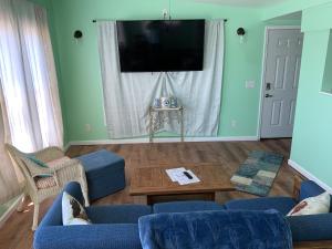 uma sala de estar com mobiliário azul e uma televisão de ecrã plano em The Boat House - Water Front, WiFi, Pet Friendly home em Norfolk