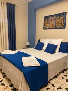 ein Schlafzimmer mit einem großen Bett mit blauen Kissen in der Unterkunft Casa Dominique in Cefalú
