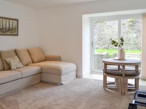 sala de estar con sofá y mesa en Kirroughtree Steading 2 - Uk42904, en Newton Stewart