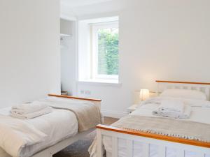 two beds in a white room with a window at Kirroughtree Steading 2 - Uk42904 in Newton Stewart