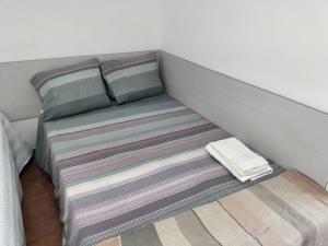 Arrifana的住宿－Bom Caminho，一张带两个枕头和毯子的床