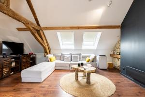 SOUS LE HAUT DES REMPARTS في بون: غرفة معيشة مع أريكة بيضاء وطاولة