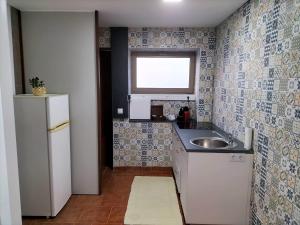 a small kitchen with a sink and a window at Bom Caminho in Arrifana