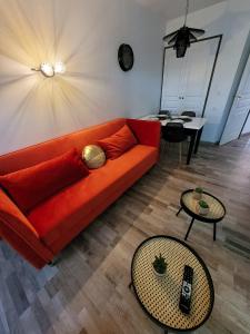 uma sala de estar com um sofá laranja e uma mesa em Magnifique appartement 2 pièces em Deauville