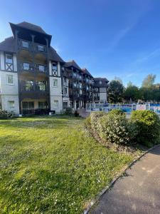 um grande edifício com um jardim de relva em frente em Magnifique appartement 2 pièces em Deauville