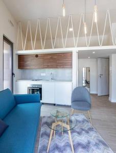 a living room with a blue couch and a kitchen at Mini Condos® 13 D1 - Modern Studio with mezzanine in Tivat