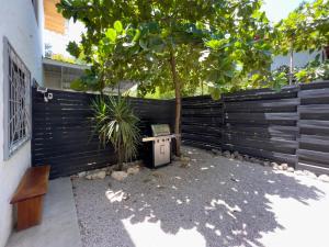 une clôture avec un arbre et un banc dans une cour dans l'établissement Salt Nosara, à Nosara