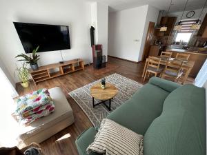 a living room with a couch and a flat screen tv at Živa Blatnica in Blatnica