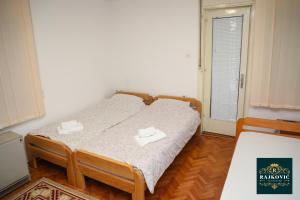 a bedroom with a bed with two towels on it at Apartmani Rajkovic in Soko Banja