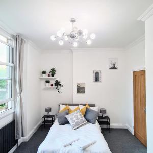 a white bedroom with a bed and a window at Stunning 2 Bed 2 Bath Luxury London Apartment! in Forest Hill