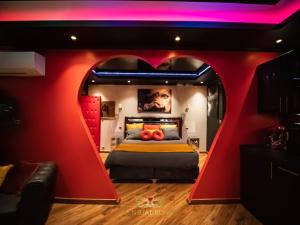 - une chambre avec un lit en forme de cœur et un mur rouge dans l'établissement Sensual Room Love Room Nancy Sauna Double Douche, à Nancy