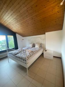 a bedroom with a bed and a wooden ceiling at BellaVista Cureglia in Cureglia