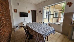 Cette chambre dispose d'une table avec des chaises et d'une fenêtre. dans l'établissement Hermosa casa PH equipada y con patio. Aestrenar, à Mar del Plata