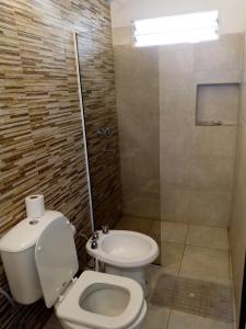 a bathroom with a toilet and a shower and a sink at "Village" Amplia CASA boutique con parrilla y 2 garages in Corrientes
