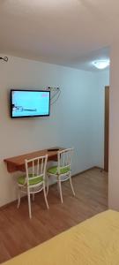 Cette chambre dispose d'une table, de deux chaises et d'une télévision murale. dans l'établissement Villa Ruzica, à Trogir