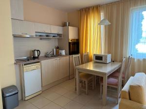 a small kitchen with a table and a microwave at Apartments in complex Harmony hills in Rogachevo