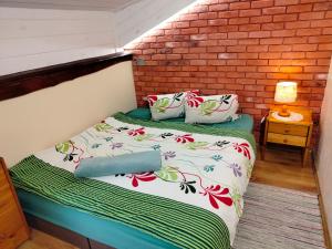 a bed in a room with a brick wall at Pokoje Gościnne "Justyna" in Kroczyce