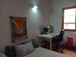 a bedroom with a bed and a desk with a computer at Casita Mona y Acogedora in Alaquas