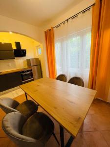 a dining room with a wooden table and chairs at Apartmani Roko&Lovre Paklenica in Starigrad