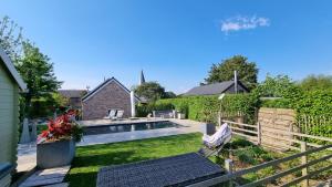 un patio trasero con piscina y valla en Maison typique privée - Sart Lez Spa - PINE COTTAGE- charme piscine, en Sart