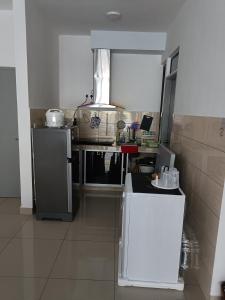 a small kitchen with a stove and a refrigerator at Cold house in Cameron Highlands