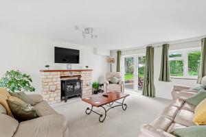 uma sala de estar com dois sofás e uma lareira em Wheelbarrow Cottage em Bengeworth