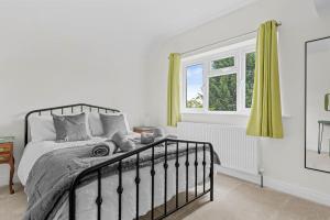 Schlafzimmer mit einem Bett und einem Fenster in der Unterkunft Wheelbarrow Cottage in Bengeworth