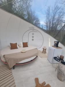 a bedroom with a bed in a glass house at Camping les lodges du Tarn in Mostuéjouls