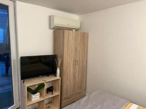 Schlafzimmer mit einem Bett, einem TV und einem Schrank in der Unterkunft Abrilove in Castres