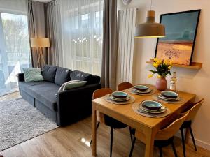 a living room with a table and a couch at Apartament Słoneczny Dziwnów in Dziwnów