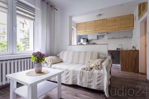 a living room with a white couch and a table at Apartament Studio 24 in Zamość